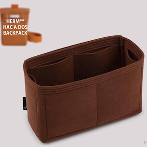 Könnte beinhalten: Ein brauner Filz-Taschenorganizer mit mehreren Fächern. Der Organizer hat eine rechteckige Form mit einem strukturierten Design. Der Text "HERM** HAC A DOS BACKPACK" ist oben links sichtbar. Das Markenlogo "JOYINBAG" befindet sich unten rechts.