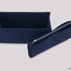 May include: A navy blue felt bag organizer with multiple compartments and a zippered pocket. The organizer is designed to fit inside a larger bag, helping to keep items organized.