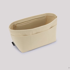 Pu&ograve; includere: Organizzatore per borsa in feltro beige con pi&ugrave; scomparti e una tasca con cerniera. L'organizzatore &egrave; progettato per adattarsi all'interno di una borsa pi&ugrave; grande.