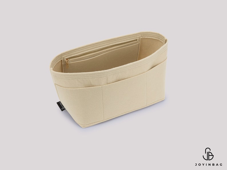 Pu&ograve; includere: Organizzatore per borsa in feltro beige con pi&ugrave; scomparti e una tasca con cerniera. L'organizzatore &egrave; progettato per adattarsi all'interno di una borsa pi&ugrave; grande.