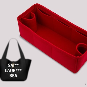 Puede incluir: Organizador de bolso de fieltro rojo con múltiples compartimentos y un bolsillo con cremallera. El organizador está diseñado para caber dentro de un bolso tote más grande. El organizador se muestra junto a un bolso tote negro con el texto "SAI***LAUR***BEA" impreso en él.