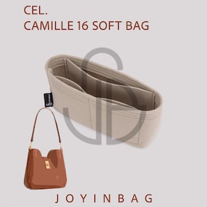 May include: A tan-colored bag organizer with multiple compartments and a brown leather handbag. The handbag has a gold-colored clasp and handle attachments. The text "CEL. CAMILLE 16 SOFT BAG" is at the top.