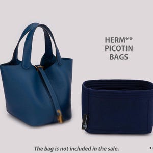 Op de afbeelding: Een blauwe leren emmertas met twee handvatten en een riemsluiting, naast een donkerblauwe vilten tasorganizer. De tekst HERM** PICOTIN BAGS is zichtbaar boven het inzetstuk en de tekst The bag is not included in the sale staat onderaan.