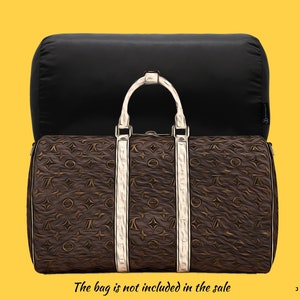 Pode incluir: Uma mala de viagem marrom e preta com um padrão de monograma branco e alças brancas. A mala não está incluída na venda. O texto "JOYINBAG" está no canto inferior direito da imagem.