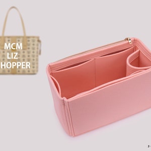 Könnte beinhalten: Rosa gefütterter Taschenorganizer mit mehreren Fächern und Reißverschluss. Der Organizer ist für eine MCM Liz Shopper-Tragetasche konzipiert.