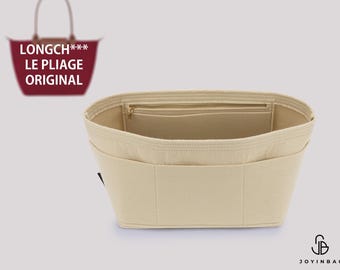 Puede incluir: Un organizador de bolso de fieltro beige con múltiples bolsillos interiores y un compartimento con cremallera. El inserto está diseñado para un bolso tote Longch*** Le Pliage Original, mostrado como un pequeño gráfico en la esquina superior.