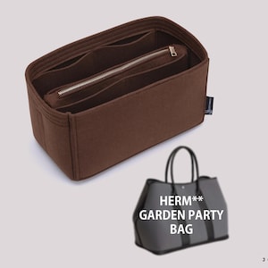 Op de afbeelding: Een bruine vilten handtas-organizer met meerdere binnenvakken en een centraal ritsvak. De inzet heeft een klein zwart stoffen label aan de zijkant. Onderaan staat een grijze draagtas afgebeeld met de tekst HERM** GARDEN PARTY BAG.