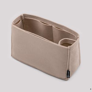 May include: Beige felt bag organizer with multiple compartments and a small pocket. The organizer is designed to fit inside a larger bag.
