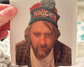 May include: White can cooler with a photo of a person wearing a red and green knit hat with the word "NAUGHTY" on it.