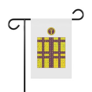 May include: A white garden flag featuring a purple circle with a yellow letter T at the top. Below, a grid pattern alternates between purple and yellow squares, each containing unique, stylized symbols in contrasting colors.