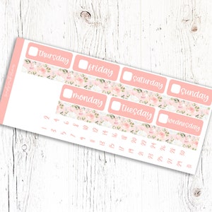 May include: A set of pink and white floral patterned planner stickers with days of the week and numbers 1 through 31. The stickers are designed for use in a planner or journal.