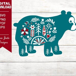 May include: Teal blue silhouette of a bear with a Scandinavian folk art design featuring red and white flowers, leaves, and geometric shapes.