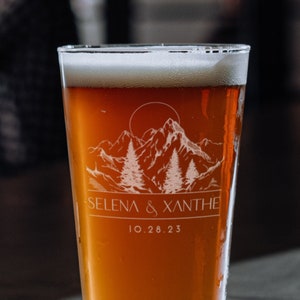 16oz beer glass laser etched with a modern forest design and personalized with names and a date.