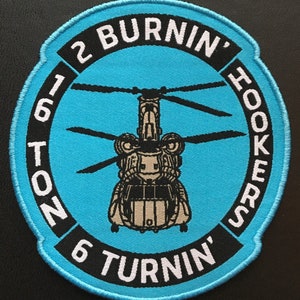 May include: Embroidered patch with a light blue background featuring a helicopter design. The patch has a black border with white text that reads "2 Burnin' Hookers" and "16 Ton 6 Turnin'".
