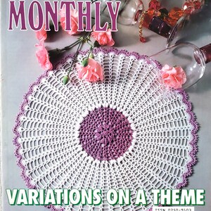 Puede incluir: Una portada de revista de crochet con un encaje de crochet blanco y morado con el título "Variaciones sobre un tema". La revista se llama "Crochet Monthly" y tiene el número 196.