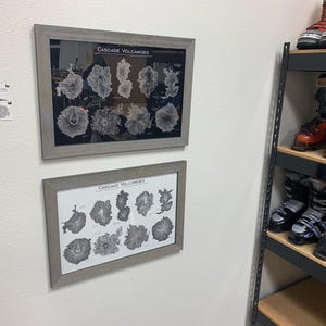 Peut inclure: Deux impressions encadr&eacute;es d'illustrations en noir et blanc de volcans de la Cascade. L'impression sup&eacute;rieure comporte 12 illustrations et l'impression inf&eacute;rieure en comporte 10. Les impressions sont accroch&eacute;es &agrave; un mur blanc.