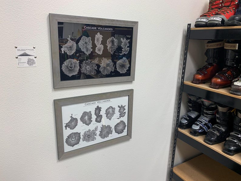 Peut inclure: Deux impressions encadr&eacute;es d'illustrations en noir et blanc de volcans de la Cascade. L'impression sup&eacute;rieure comporte 12 illustrations et l'impression inf&eacute;rieure en comporte 10. Les impressions sont accroch&eacute;es &agrave; un mur blanc.