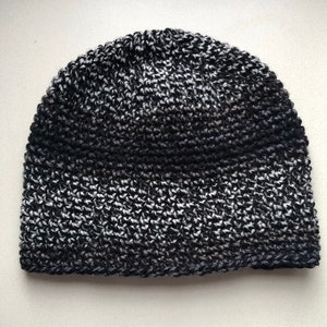 May include: A black and white knit beanie hat with a black band around the bottom.