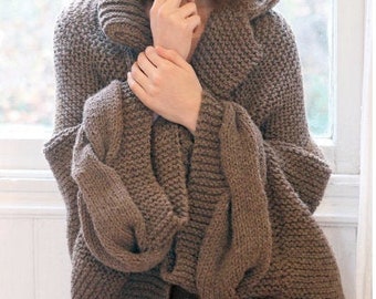 May include: A brown knitted cardigan with a large collar and long sleeves. The cardigan is made of a chunky yarn and has a relaxed fit.