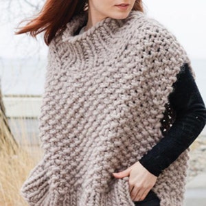 May include: A chunky knit sleeveless sweater in a light beige color with a high neck and a slightly flared hem.