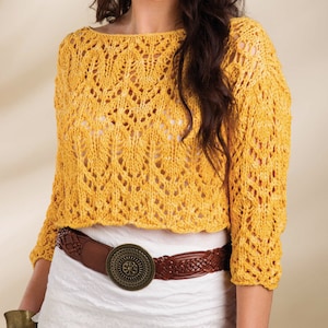 May include: A yellow crocheted sweater with a loose fit and a delicate openwork pattern. The sweater has a cropped length and a slightly ruffled hem.