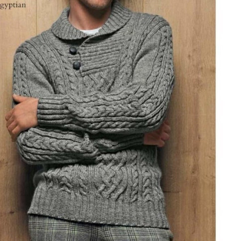 May include: A grey cable knit jumper with a collared neckline and three buttons. The jumper has a textured pattern and long sleeves.