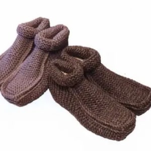 Può includere: Un paio di calzini da pantofola in maglia marrone. I calzini sono realizzati in un materiale morbido e caldo e hanno una vestibilità comoda.