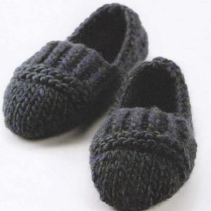 May include: A pair of dark gray knitted slippers with a textured design. The slippers have a pointed toe and a flat sole.