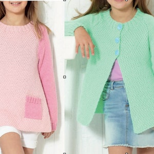 Könnte beinhalten: Zwei Strickpullover für Kinder, einer rosa mit einer Tasche und einer hellgrün. Beide Pullover haben ein strukturiertes Strickmuster.