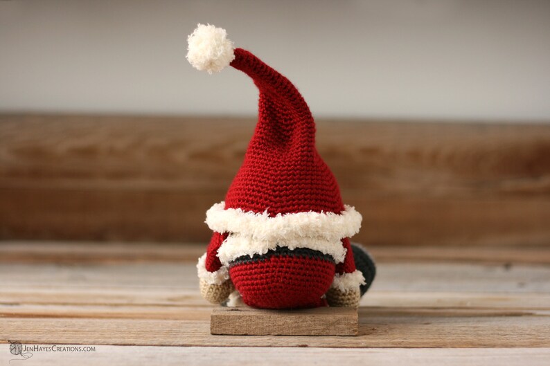 Back view of the  Crochet Santa Gnome sitting on a wood background.