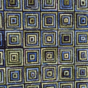 May include: A rectangular rug featuring a repeating geometric pattern of concentric squares. The design consists of alternating shades of blue, green, and black yarn, creating a textured grid of nested square motifs across the entire surface.