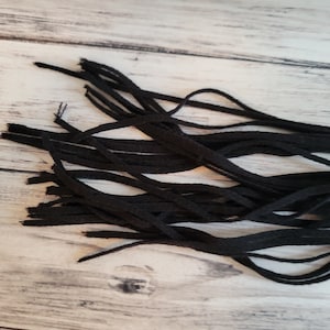 May include: A bundle of black fabric tassels, likely for use in crafting or decorating.