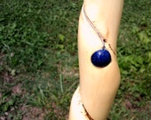 50-3 4 quot Twisted Wild Cherry Walkingstick with a glossy bark grip, black reflective wrist strap, upper inlay and a blue centerpiece.