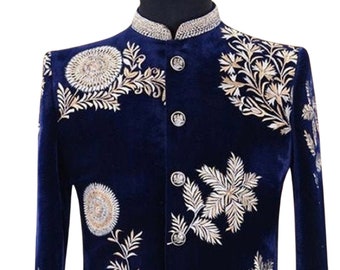 May include: A navy blue velvet jacket with gold embroidery of floral designs. The jacket has a mandarin collar and button closure. The text "AJIRNA ROYAL DESIGNER" is visible at the bottom of the image.