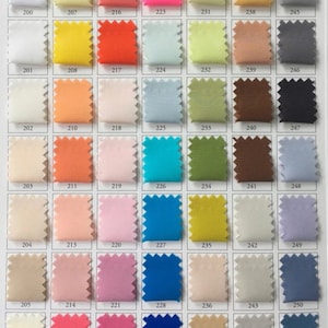 May include: A colour chart with 36 fabric swatches, each numbered with a three-digit number. The swatches are arranged in six rows of six swatches each. The swatches are a variety of colours, including white, yellow, orange, red, pink, blue, green, brown, and grey.