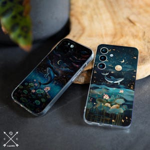 May include: Two phone cases featuring a dark blue background with a whale leaping from the water. The cases depict a starry night sky with a crescent moon and a full moon. Lotus flowers and leaves are also present in the water.