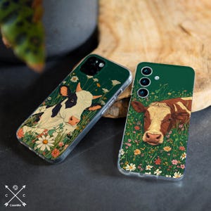 May include: Two phone cases with a green background and a cow illustration. The cow on the left case is black and white, and the cow on the right case is brown and white. Both cases have a floral design around the cows.