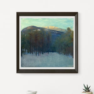 May include: A framed landscape painting depicts a snow-covered valley and a mountain range under a light blue sky. The artwork features a forest of tall, dark green trees in the mid-ground, with the mountain in the background. The painting is in a dark brown frame.