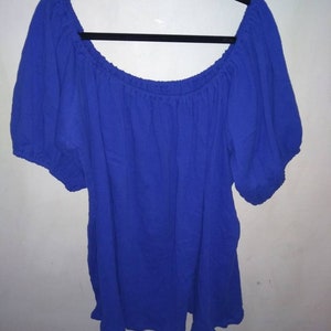 May include: A royal blue off-the-shoulder top with short, puffed sleeves.