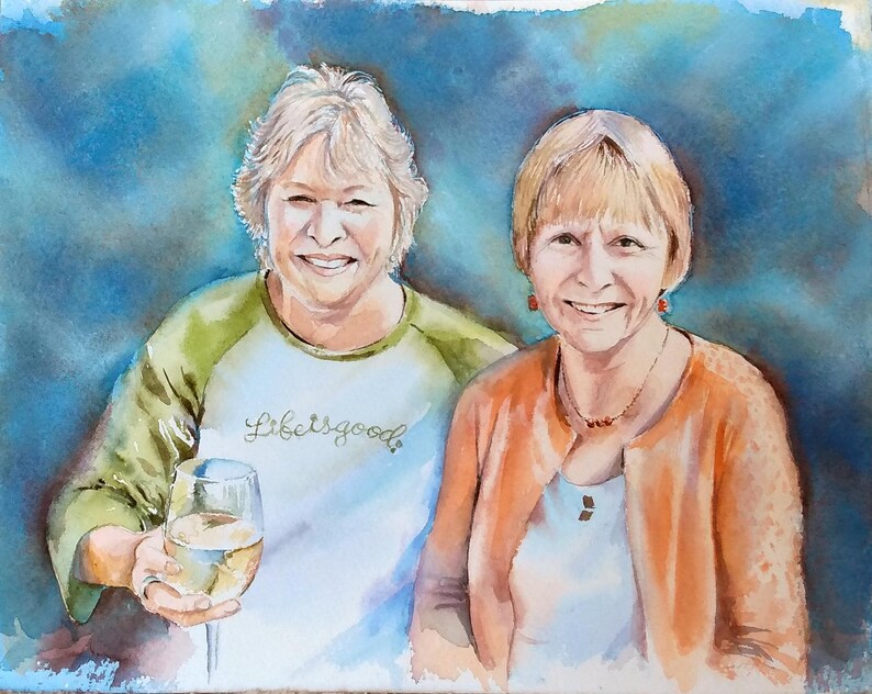 K&ouml;nnte beinhalten: Ein Aquarellgem&auml;lde von zwei l&auml;chelnden Personen. Die Person links tr&auml;gt ein wei&szlig;-olivgr&uuml;nes Raglan-Shirt mit dem Text Life is good und h&auml;lt ein Weinglas. Die Person rechts tr&auml;gt eine orangefarbene Strickjacke &uuml;ber einem wei&szlig;en Oberteil.