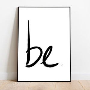 May include: A black and white print with the word "be" written in a bold, brushstroke font.