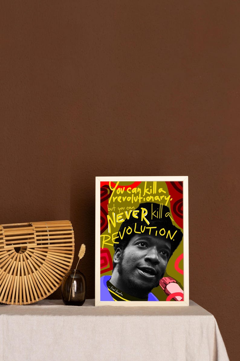 Puede incluir: Una impresi&oacute;n art&iacute;stica enmarcada con un retrato en blanco y negro de Fred Hampton y el texto "You can kill a revolutionary, but you can NEVER kill a REVOLUTION". La obra de arte utiliza los colores rojo, verde y amarillo.