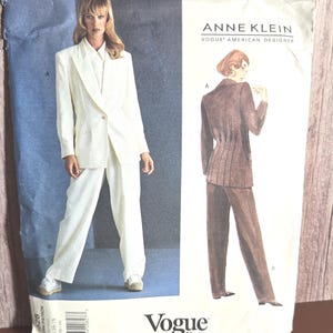 May include: A vintage Vogue Patterns sewing pattern featuring an Anne Klein design. The pattern shows a woman's suit with a blazer and pants. The cover has a blue and white background with the Vogue Patterns logo.