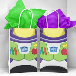 May include: Two gift bags with white handles and a printed design of Buzz Lightyear from the Toy Story film. The bag on the left has green tissue paper inside and the bag on the right has purple tissue paper inside.