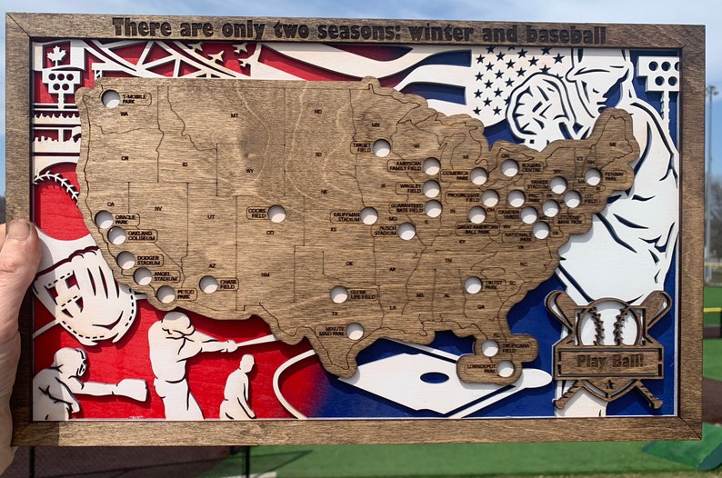 May include: A wooden map of the United States with baseball stadiums marked. The map is surrounded by a wooden frame and features a baseball glove, bats, and a baseball. The text "There are only two seasons: winter and baseball" is at the top of the map. The text "Play Ball" is at the bottom of the map.