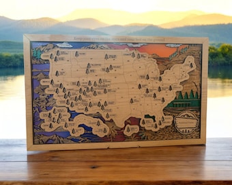May include: A wooden map of the United States with the names of all the National Parks marked. The map is surrounded by a colorful border and the text "Keep your eyes on the stars and your feet on the ground" is printed at the top.