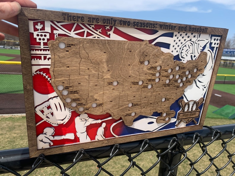 May include: A wooden map of the United States with baseball stadiums marked. The map is surrounded by a red, white, and blue baseball-themed design. The text "There are only two seasons: winter and baseball" is at the top of the map.