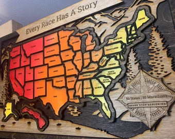 Puede incluir: Un mapa de madera de los Estados Unidos con cada estado delineado en un tono diferente de naranja, rojo y amarillo. El mapa está montado sobre un fondo de madera oscura. El texto "Every Race Has A Story" está en la parte superior del mapa. Una rosa de los vientos con el texto "50 States 50 Marathons Never Stop Exploring" está en la esquina inferior derecha.