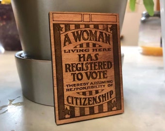 Una donna che vive qui si è registrata per votare - Magnete del suffragio femminile basato su poster vintage
