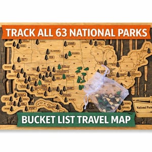 May include: Wooden map of the United States with the text "TRACK ALL 63 NATIONAL PARKS" and "BUCKET LIST TRAVEL MAP". The map is framed in a light wood color, with a dark wood background. Small green tree-shaped pins are included.
